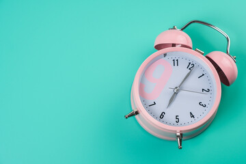 Detail close up of the old pink vintage alarm clock on colour background with free copy space.