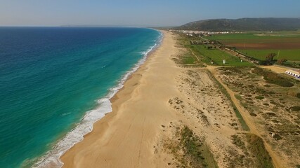 Espectacular foro aerea de larga playa virgen con el mar de color turquesa y el cielo azul