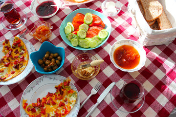 Homemade Turkish breakfast with Turkish tea, green olive, jam, colorful omelette and honey.