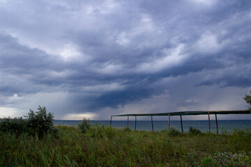 Before storm and rain on the sea. On the island. Nature. Coast of the ocean. Dark clouds. 