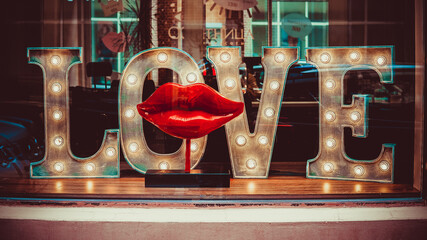 the inscription love in the window with red lips