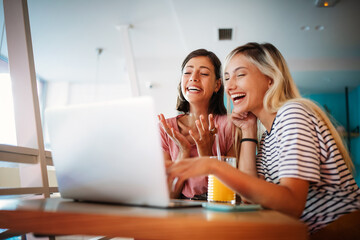 Young female friends surfing the internet and having fun together