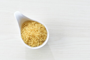 Short pasta spaghetti angel hair displayed in containers on white background
