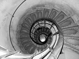 black and white photo of a spiral staircase going down