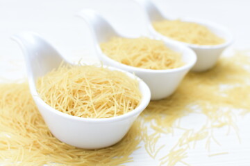 Short pasta spaghetti angel hair displayed in containers on white background