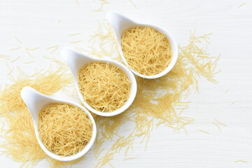 Fototapeta na wymiar Short pasta spaghetti angel hair displayed in containers on white background
