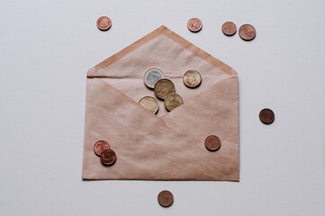 A brown envelope with money in it and a blue pen on top. View from above and a white background