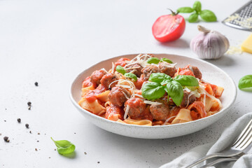 Pasta fettuccine with meatballs, parmesan, tomatoes, basil.