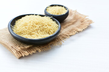 Short pasta spaghetti angel hair displayed in containers on white background
