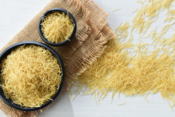 Short pasta spaghetti angel hair displayed in containers on white background