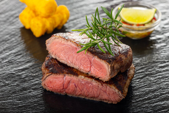 slices of grilled steak on black slate