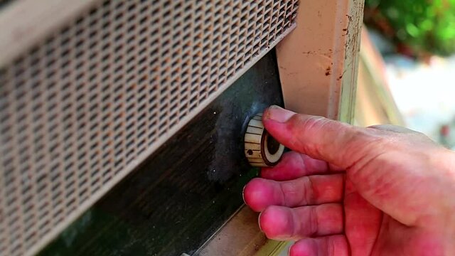 Hand of an old man searching for station on the vintage radio. Old retro radio tuning
