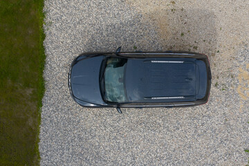 black SUV in green grass photographed from the air