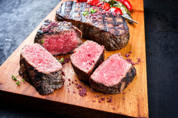 Gegrilltes dry aged Wagyu Roastbeef Steak vom Rind mit Tomaten und Chili als closeup auf einem...