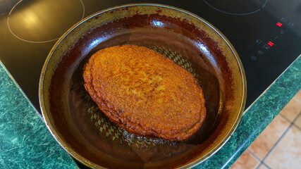 Big potato pancake are fried in a hot pan with oil. Top view. Kitchen concept.