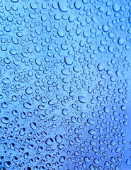 After the rains, raindrops on the glass formed a natural textural pattern. Rainwater gathered in drops on the clear glass of the window. Textured background.