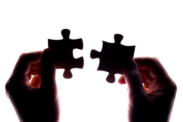 Silhouettes of two puzzle elements in the hands. They can match perfectly.