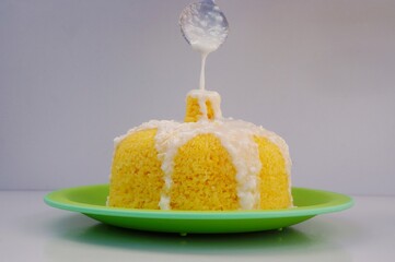 Coconut milk being poured into the Couscous with a spoon. Brazilian couscous (Cuscuz Brasileiro).
