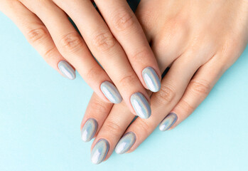 Young adult woman's hands with holographic fashionable nails