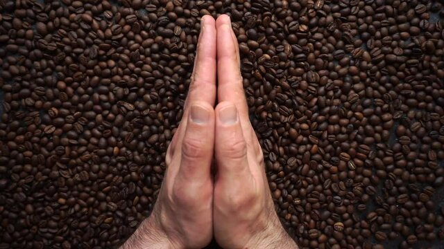 Coffee beans background. Hands spreading roasted coffee beans for free space for text. Top view, cope space.