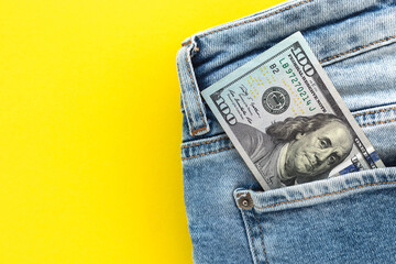 Closeup of  100 dollar bill sticking out from jeans pocket. American banknote. Flat lay, copy space.