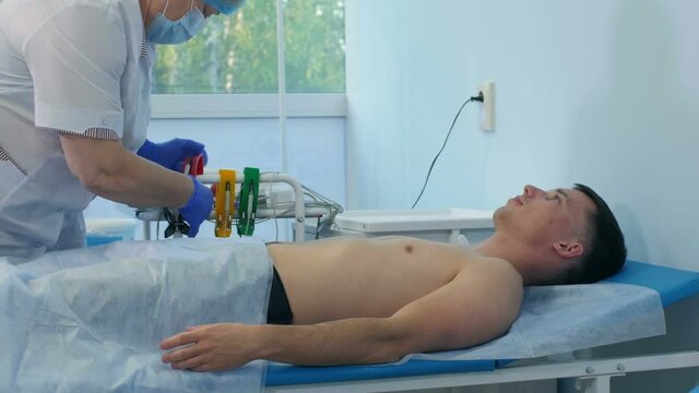 Nurse preparing male patient for ECG test