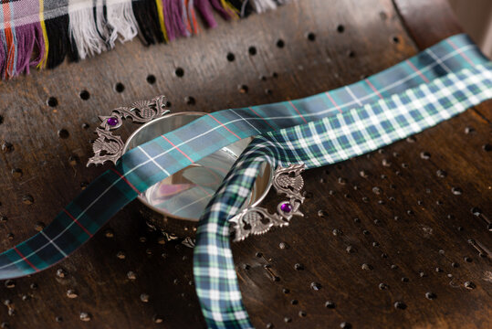 Quaich With Tartan Ribbon On Wooden Bench