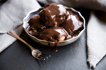 Delicious eclairs with cream and chocolate frosting on a plate
