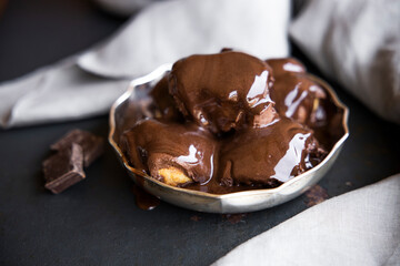 Delicious eclairs with cream and chocolate frosting on a plate