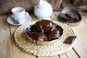 Delicious eclairs with cream and chocolate frosting on a plate