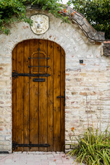 Fototapeta na wymiar Old wooden door on brick fence wall