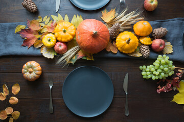 Fall dark place setting with leaves and pumpkins. Centerpieces Thanksgiving Day. Party. View from...