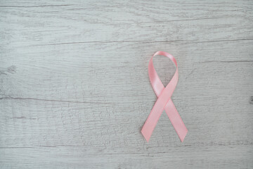 Pink cancer ribbon on a grey background