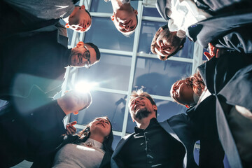 close up. group of happy young business people standing in a circle.