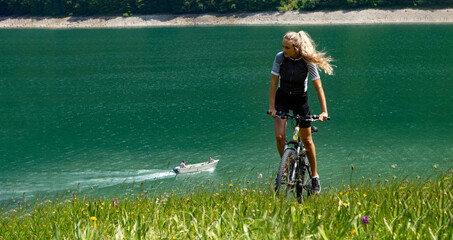 Life style woman with long blond hair on mountain bike in Swiss