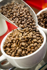 Food styled display of coffee beans being poured from soup into a white cup