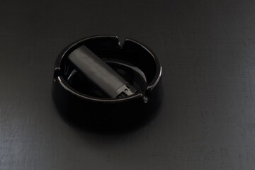 black electronic lighter and an ashtray without logo