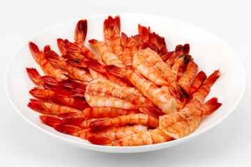 Plenty of boiled shrimps on a white plate, as background for restaurant menu, cafe, cookbook, advertising business. As backdrop for menus, cookbooks, advertisements and other culinary projects