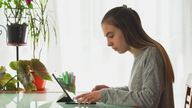 Little girl doing homework at home on the computer