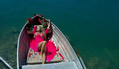 Life style woman with red dress and roses on a lake