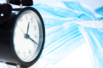 Surgical face masks and clock indicating the time