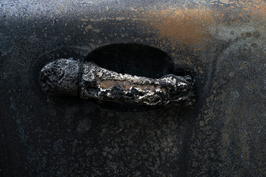 A burnt passenger car burned to the ground during a fire and strike. Fused plastic and metal auto parts