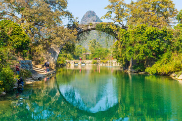 Fototapeta premium YANGSHUO, CHINA, 6 DECEMBER 2019: Fuli bridge on the Yulong River in the countryside of Yangshuo