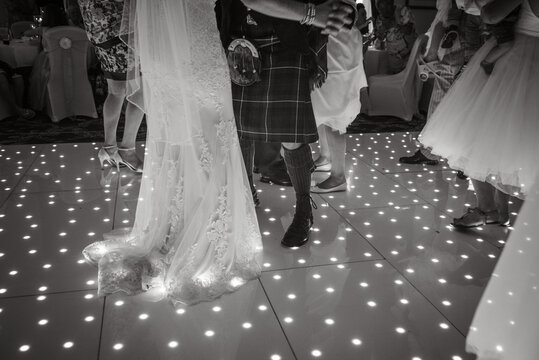 Bride and grooms feet on light up dancefloor