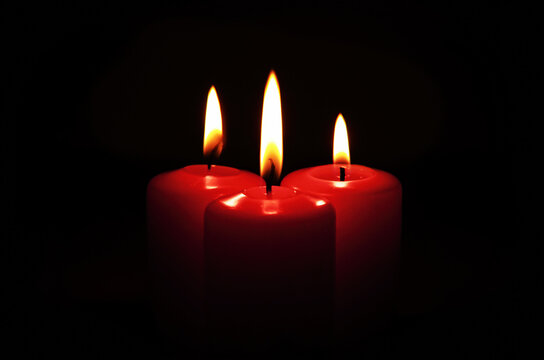Three red burning candles on the black background. Different rituals. Memory and sorrow. Rest in peace.