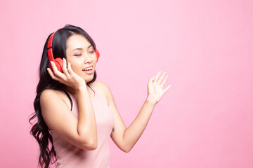 Pretty asian girl listening music with her headphones.