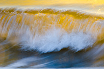 Close-up of backlit breaking wave, long exposure