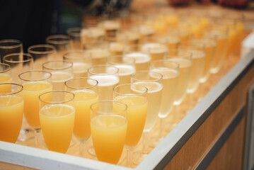 Rows of glasses with various colorful drinks standing on buffet table. Celebration, birthday, party, wedding concept.