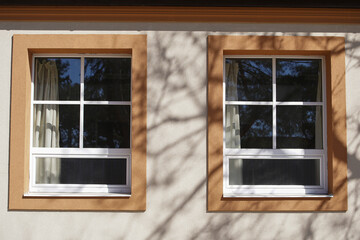Old double window with wooden shadow on side of house