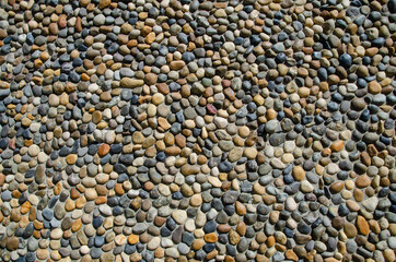 Pebble wall texture. Stone wall made of pebbles